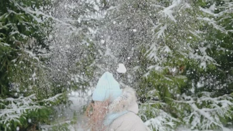 A girl throws snow over herself while standing in the park Stock Footage 144323746