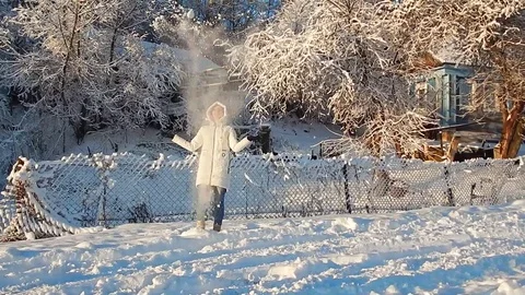 Girl throws snow in the sun Stock Footage
