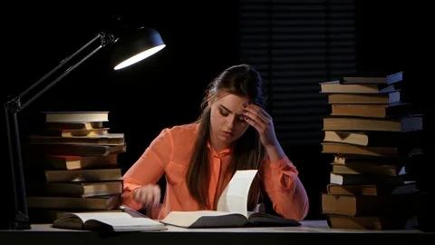 Girl thumbs through the book and it hurts headaches. Black background Stock Footage