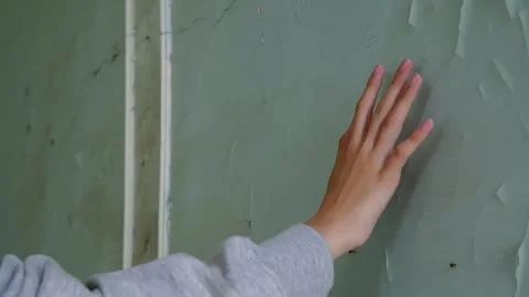 Girl touching deteriorated plaster wall with peeling paint Stock Footage 342087519