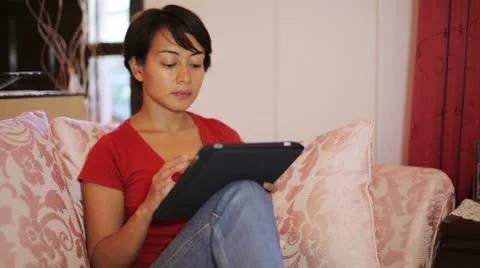 Girl touching tablet computer screen at home Stock Footage