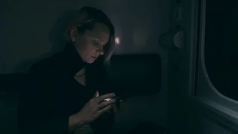 The girl is on the train at night. Sits on the train and uses a smartphone Stock Footage 76536837