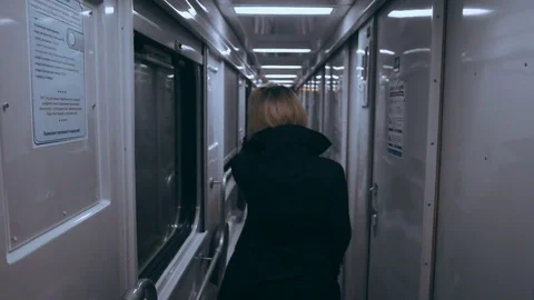 Girl on a train standing in an empty corridor and leaning on the window Vídeo Stock 76538431