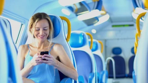 Girl in the train using smartphone and smiling. Travelling by the train. Stock Footage 80310393