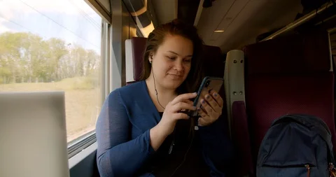 Girl on Train using Smartphone Stock Footage 129787664