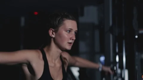 The girl trains on a multifunctional simulator in a dark room Stockbeeldmateriaal 118736699