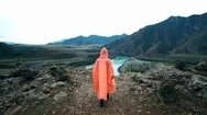Girl Traveler In Orange Raincoat Coming To The Edge Of The Cliff In The Stock Footage