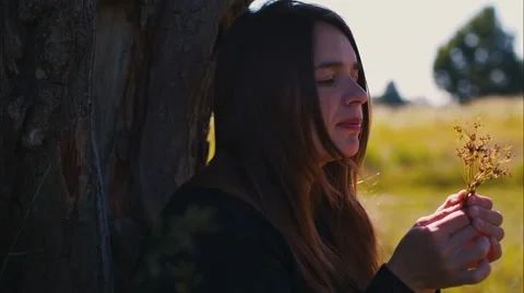 Girl at a Tree Eats Grass and Smiling Stock Footage 52009023