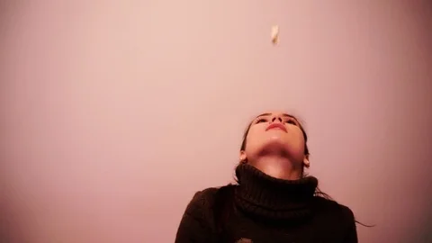 Girl try to catch pop corn, but fail. Then start eating. Slow motion Stock Footage 86487005