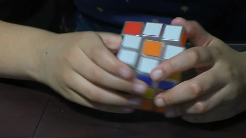 A girl trying to solve rubik cube Stock Footage 128198881