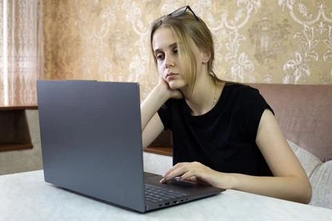 Girl is trying to solve work problem while sitting at laptop in home Foto stock