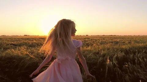 Girl is turned in the field at sunset Video stock 64807828