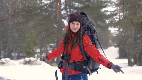 Girl turning around under heavy snow. Traveler, Hiker positive portrait in Stock Footage