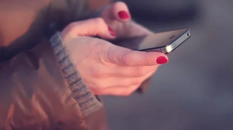 Girl types messages using a smartphone outdoors Stock Footage 49740013