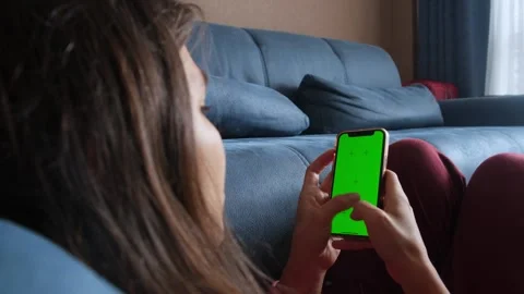 Girl types text message on mobile phone with green screen. Chatting concept Stock Footage 242907930