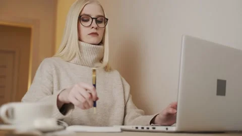 Girl typing on the computer and taking notes Stock Footage 146879415
