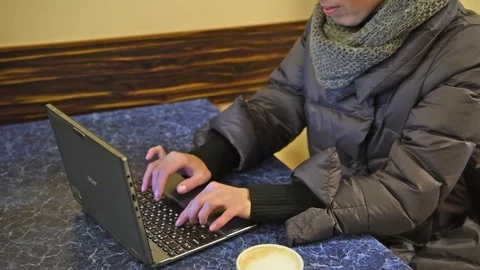 The girl is typing text on a laptop computer. A cup of coffee 5 Stock Footage 83462727