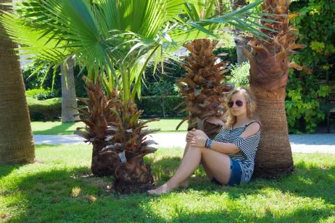 Girl under a palm tree Stock Photos
