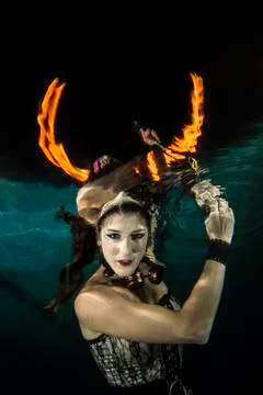 Girl underwater with firehorn Stock Photos