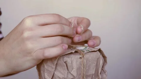 Girl unwrap creative present box in organic zero waste craft paper gift wrapping Stock Footage 165407304