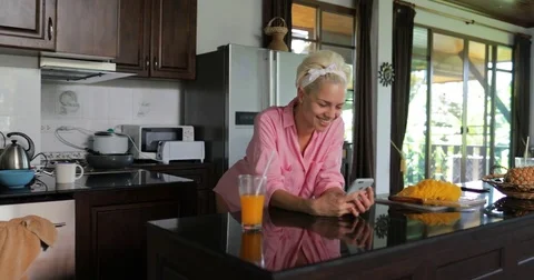Girl Use Cell Smart Phone In Kitchen Studio Chatting Online Young Woman Drink Stock Footage