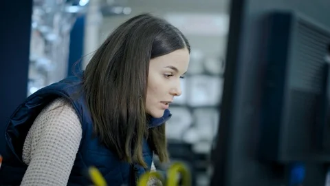 The girl uses a computer to pay with a client in the office Stock Footage 122732704