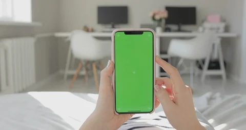 Girl Uses Phone With Green Screen. Home Environment. Scroll, Tap. Stock Footage