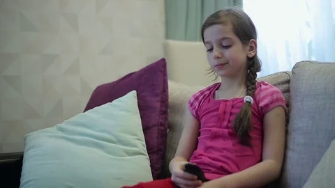 Girl uses remote control tv Stock Footage 73359020