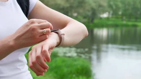 A girl uses a smart watch while walking in a summer park. Stock Footage 142364100