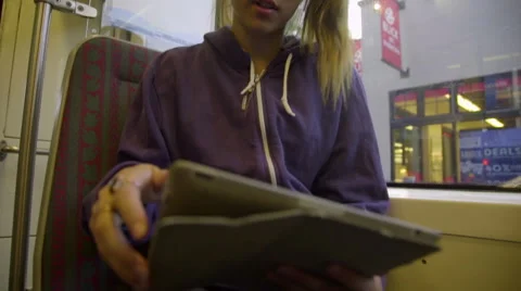 Girl uses tablet on max train Stock Footage 54097932