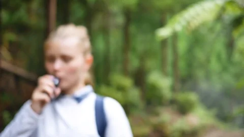 Girl uses vape in park Stock Footage 101856460