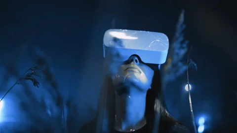 Girl uses virtual or augmented reality glasses in magic atmosphere of blue neon Vídeos de archivo 135456716