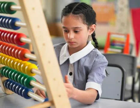 Girl Using Abacus In Classroom Stock Photos