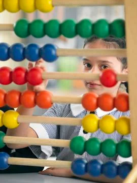 Girl Using Abacus In Classroom Stock Photos