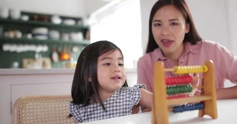 Girl using abacus to count with Mother Stock Footage 81084249