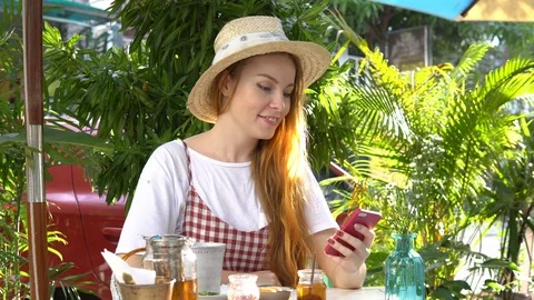 Girl using app on cellphone while drinking tea outdoors. Stock Footage 88668026