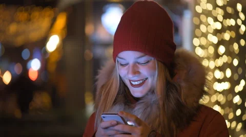 Girl using a cell phone outdoors at night. Stock Footage 58503300