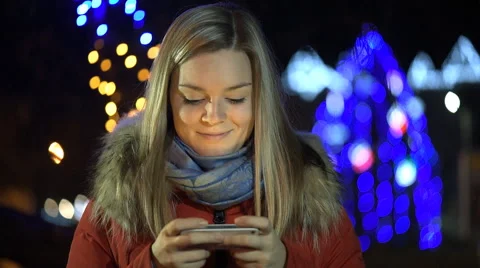 Girl using a cell phone outdoors at night. Stock Footage 59163211
