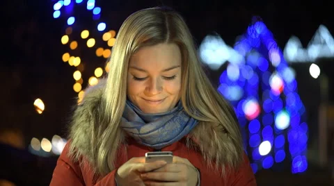 Girl using a cell phone outdoors at night. Video stock 59163460
