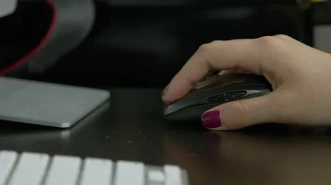 Girl using computer mouse on a dark desk with her keyboard showing Vídeo Stock 59842067