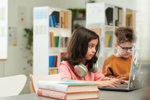 Girl using Computer in School Library Studying IT 库存照片