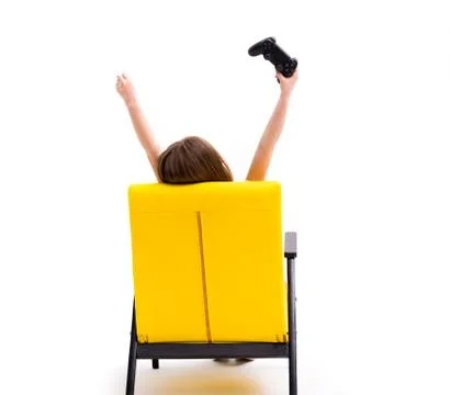 Girl using console, in chair, back to camera Stock Photos