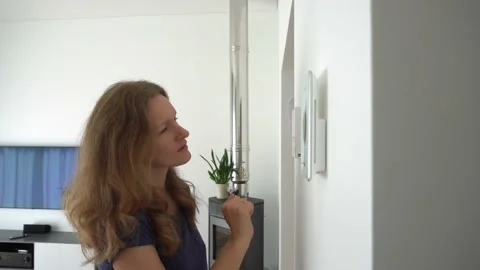 Girl using controllers to control heating, ventilation and smart home functions Stock Footage 146502974