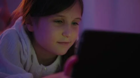 Girl Using Digital Tablet on Bed in Dark Room at Night Stock Footage 345528405