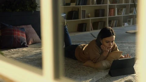 Girl using digital tablet device to surf the internet on library floor Stock Footage 104011846