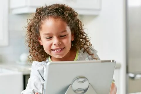 Girl using digital tablet looking down smiling Stock Photos