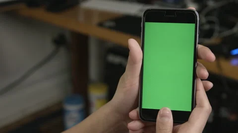 Girl using a green screen smartphone in her office Видео 62913493