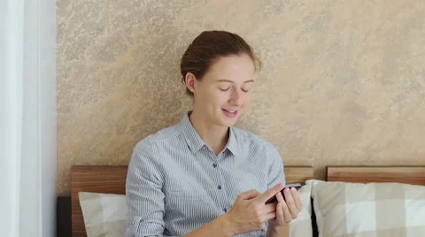 Girl using her smartphone while sitting down in bed Stock Footage 66469002