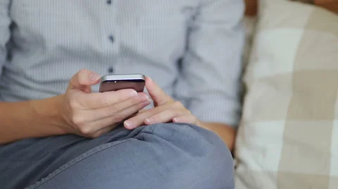 Girl using her smartphone while sitting down in bed Stock Footage 66469907