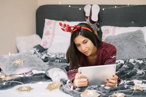 Girl using her tablet while lying in bed Stock Photos